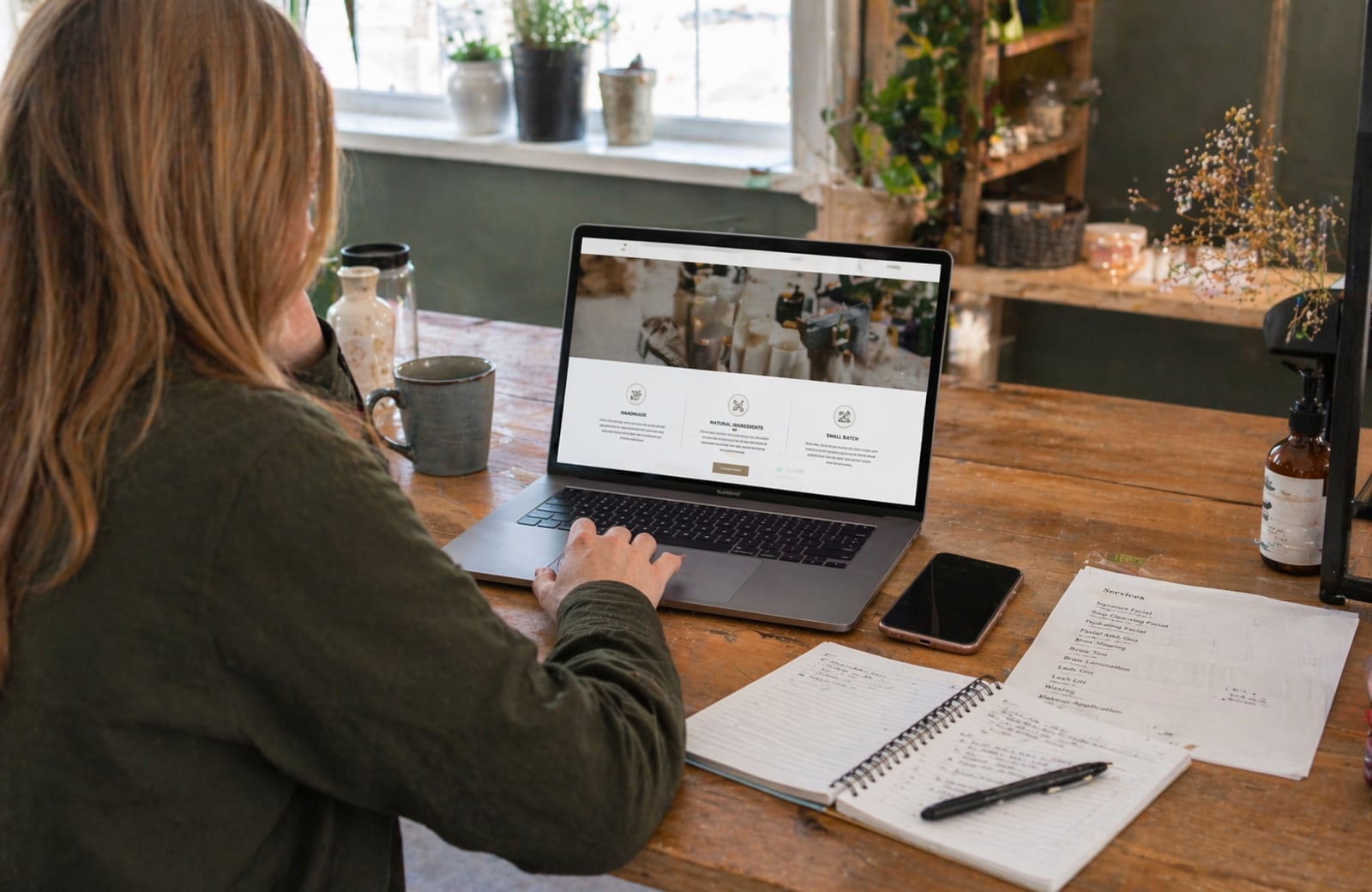 A local business owner reviewing a clean website on a laptop at a worktable.